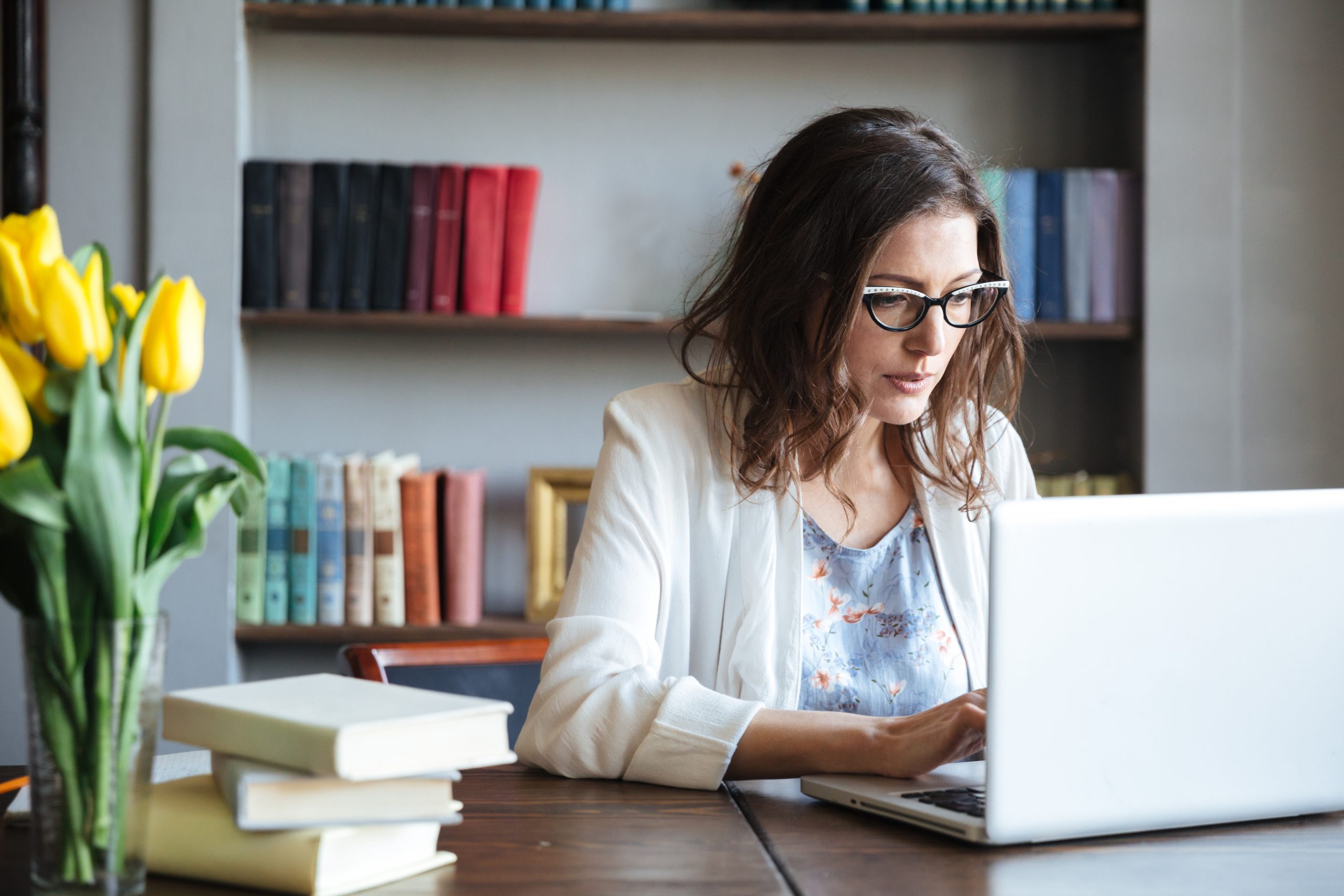 Portrait of concentrated businesswoman working on laptop at table